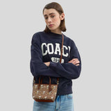 COACH Coach X Peanuts City Mini Tote Bag In Signature Canvas With Snoopy Print Tan/Brown Multi CBS83